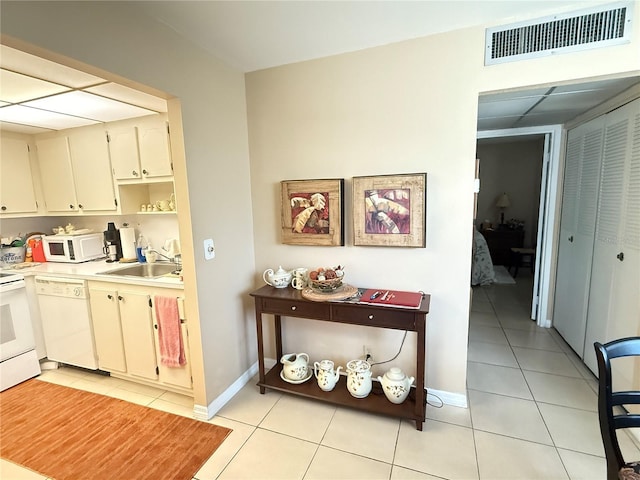 102 Cambridge Trl Unit 230, Sun City Center, FL 33573 - kitchen with white appliances, a sink, light tile patterned floors, and light countertops
