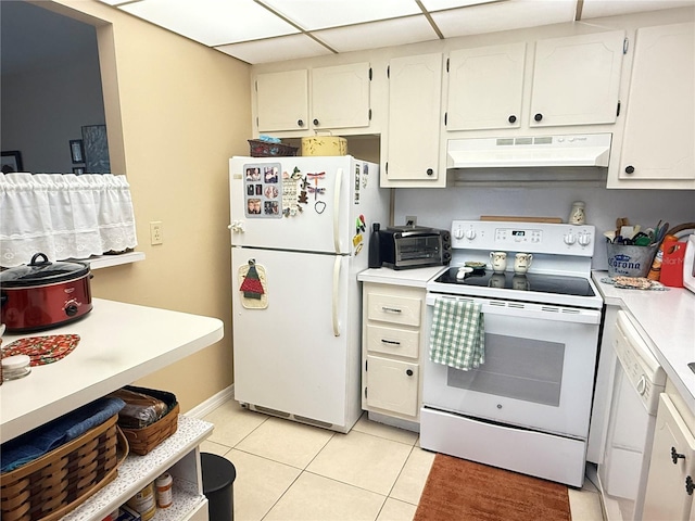102 Cambridge Trl Unit 230, Sun City Center, FL 33573 - kitchen with white appliances, under cabinet range hood, light tile patterned floors, light countertops, and baseboards