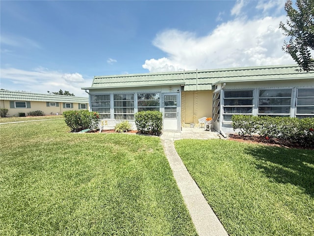102 Cambridge Trl Unit 230, Sun City Center, FL 33573 - view of front of property featuring a sunroom, a front yard, and stucco siding