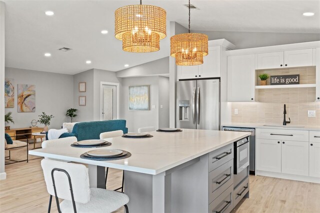 4012 Marine Pkwy, New Port Richey, FL 34652 - kitchen featuring appliances with stainless steel finishes, a sink, a chandelier, lofted ceiling, and light wood-style flooring
