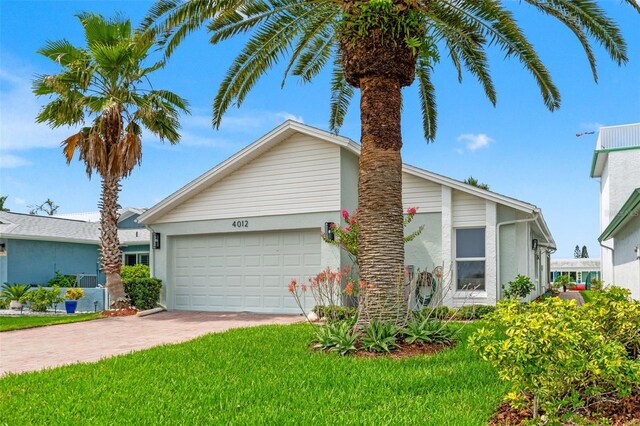 4012 Marine Pkwy, New Port Richey, FL 34652 - view of front of property with stucco siding, an attached garage, driveway, and a front lawn