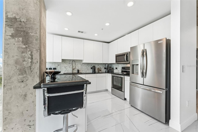 777 N Ashley Dr Unit 1506, Tampa, FL 33602 - kitchen with stainless steel appliances, dark countertops, recessed lighting, light marble finish flooring, and white cabinetry