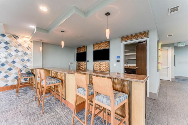 777 N Ashley Dr Unit 1506, Tampa, FL 33602 - kitchen with a breakfast bar area, light stone counters, baseboards, and recessed lighting