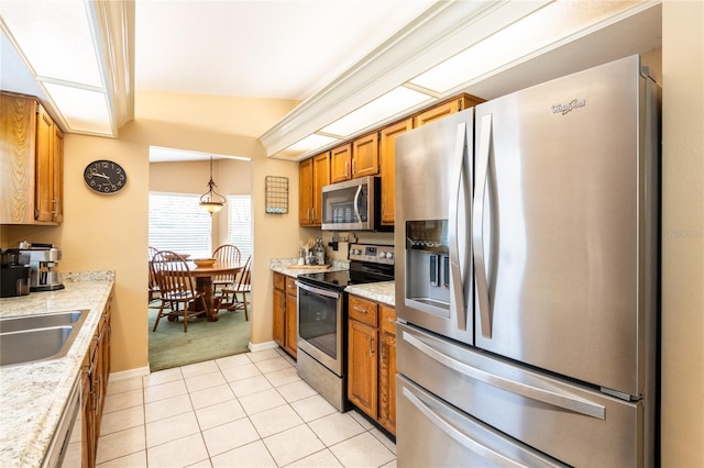 2024 Glen Forge St, Brandon, FL 33511 - kitchen featuring stainless steel appliances, brown cabinetry, light countertops, light tile patterned floors, and baseboards