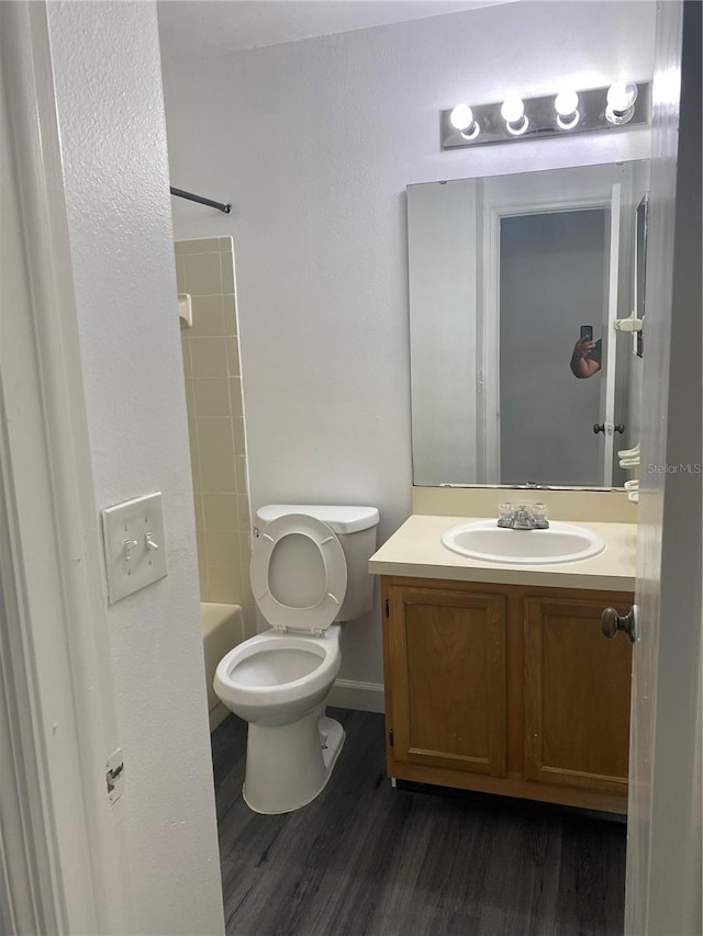 8708 Cobbler Pl, Tampa, FL 33615 - bathroom with vanity, wood finished floors, toilet, washtub / shower combination, and baseboards