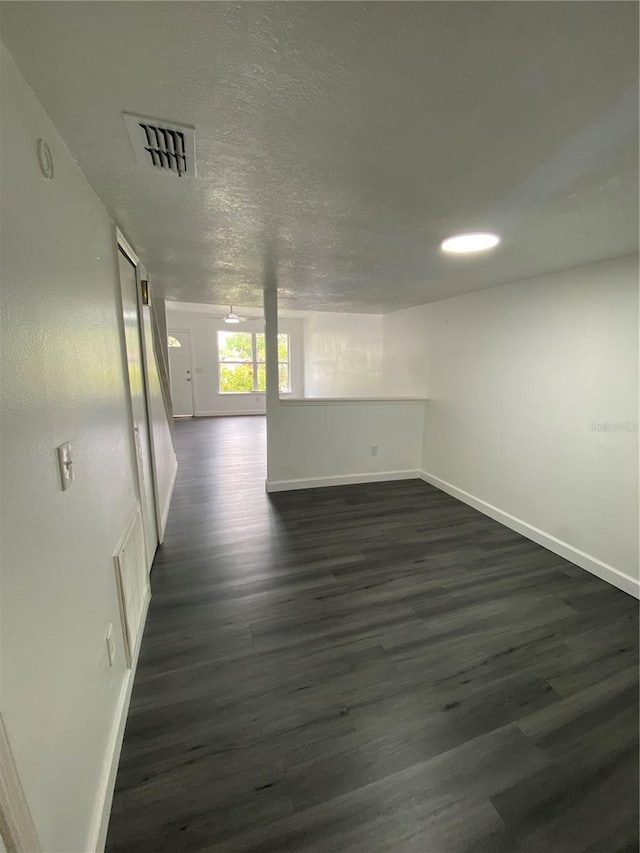 8708 Cobbler Pl, Tampa, FL 33615 - empty room featuring dark wood-type flooring, baseboards, and a textured ceiling