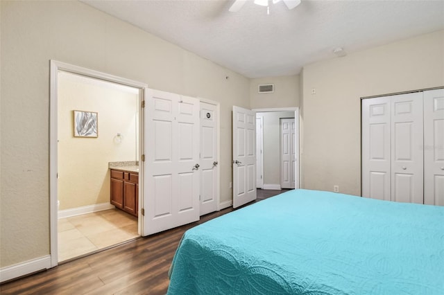 10315 Gulf Blvd Unit 302, Saint Petersburg, FL 33706 - bedroom featuring dark wood-type flooring, baseboards, connected bathroom, a ceiling fan, and a closet