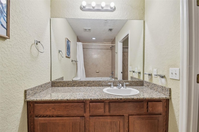10315 Gulf Blvd Unit 302, Saint Petersburg, FL 33706 - bathroom featuring a textured wall, vanity, shower / tub combo with curtain, and a textured ceiling