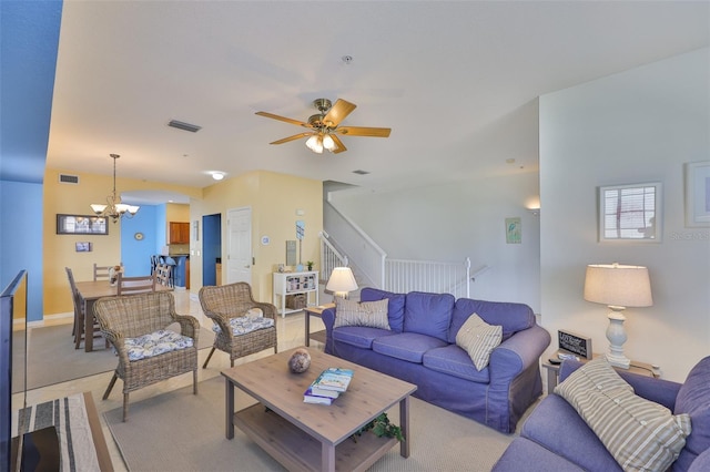 living area featuring a chandelier, a ceiling fan, and light carpet
