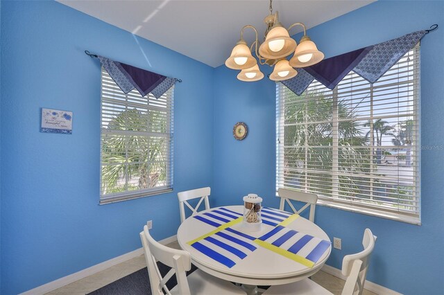 dining room with a chandelier, healthy amount of natural light, and tile patterned flooring