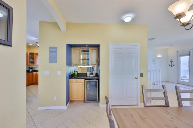 kitchen featuring wine cooler, light tile patterned flooring, and dark countertops