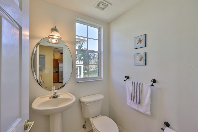 half bath featuring toilet and baseboards