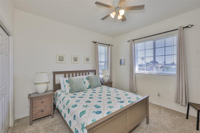 bedroom with light carpet, a ceiling fan, and a closet