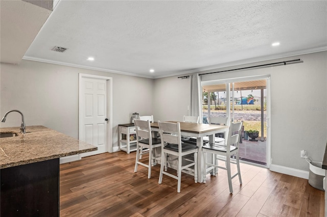6137 Halifax Dr, New Port Richey, FL 34653 - dining room featuring recessed lighting, wood finished floors, ornamental molding, a textured ceiling, and baseboards