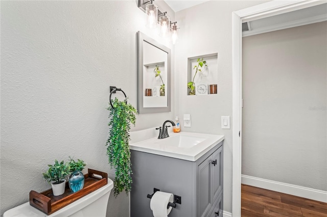 6137 Halifax Dr, New Port Richey, FL 34653 - bathroom with toilet, vanity, wood finished floors, and baseboards