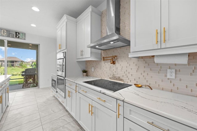 33255 Kateland Dr, Wesley Chapel, FL 33545 - kitchen featuring wall chimney exhaust hood, stainless steel appliances, white cabinets, decorative backsplash, and light stone counters