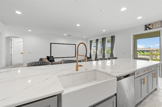 33255 Kateland Dr, Wesley Chapel, FL 33545 - kitchen with stainless steel dishwasher, a sink, open floor plan, recessed lighting, and arched walkways