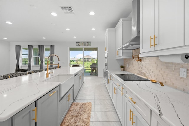 33255 Kateland Dr, Wesley Chapel, FL 33545 - kitchen with black electric cooktop, a sink, recessed lighting, wall chimney exhaust hood, and healthy amount of natural light