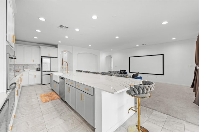 33255 Kateland Dr, Wesley Chapel, FL 33545 - kitchen with recessed lighting, open floor plan, light marble finish flooring, a breakfast bar area, and a sink