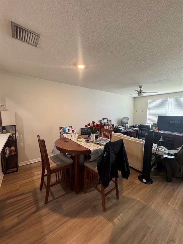 527 Glenn Cross Dr, Ruskin, FL 33570 - dining area with wood finished floors, a ceiling fan, a textured ceiling, and an office area