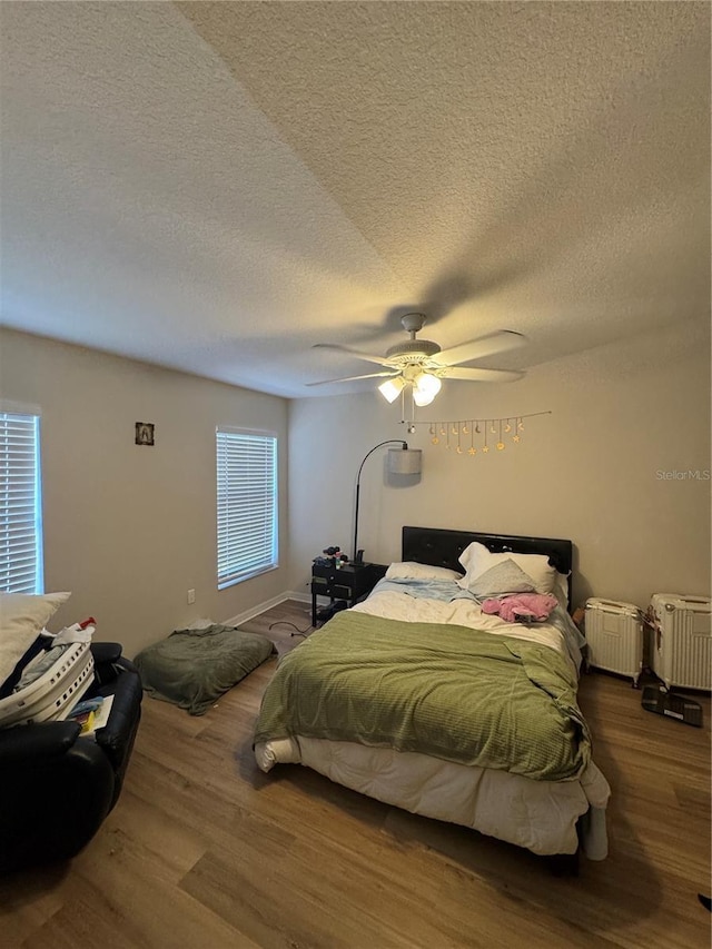 527 Glenn Cross Dr, Ruskin, FL 33570 - bedroom with wood finished floors, a textured ceiling, and ceiling fan