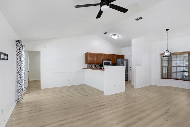1017 Cameo Crest Ln, Valrico, FL 33596 - kitchen featuring appliances with stainless steel finishes, open floor plan, vaulted ceiling, a peninsula, and light wood-style flooring