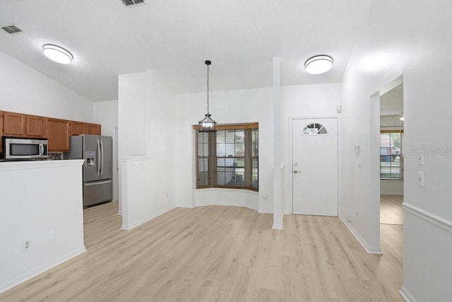 1017 Cameo Crest Ln, Valrico, FL 33596 - kitchen with stainless steel appliances, light wood-style flooring, brown cabinetry, decorative light fixtures, and baseboards