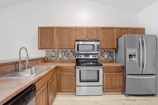 1017 Cameo Crest Ln, Valrico, FL 33596 - kitchen with stainless steel appliances, a sink, lofted ceiling, tasteful backsplash, and light countertops