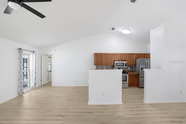 1017 Cameo Crest Ln, Valrico, FL 33596 - kitchen with stainless steel appliances, brown cabinets, lofted ceiling, ceiling fan, and light wood finished floors
