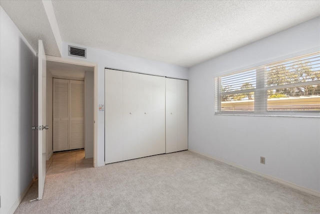 11485 Oakhurst Rd Unit 200-101, Largo, FL 33774 - unfurnished bedroom featuring carpet, a textured ceiling, a closet, and baseboards