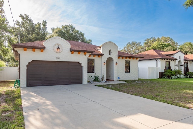 8523 N Newport Ave, Tampa, FL 33604 - mediterranean / spanish house featuring stucco siding, driveway, and a garage