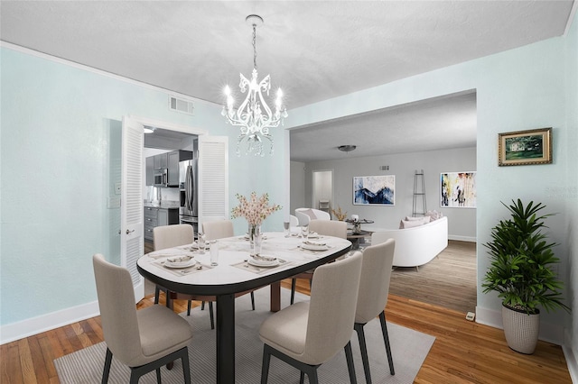 1226 SE 9th Ave, Ocala, FL 34471 - dining area with a chandelier, wood finished floors, and baseboards