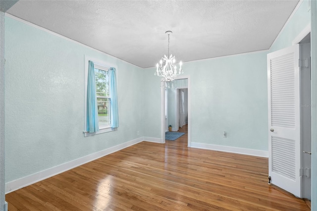 1226 SE 9th Ave, Ocala, FL 34471 - unfurnished room featuring a chandelier, light wood-style flooring, baseboards, a textured ceiling, and crown molding