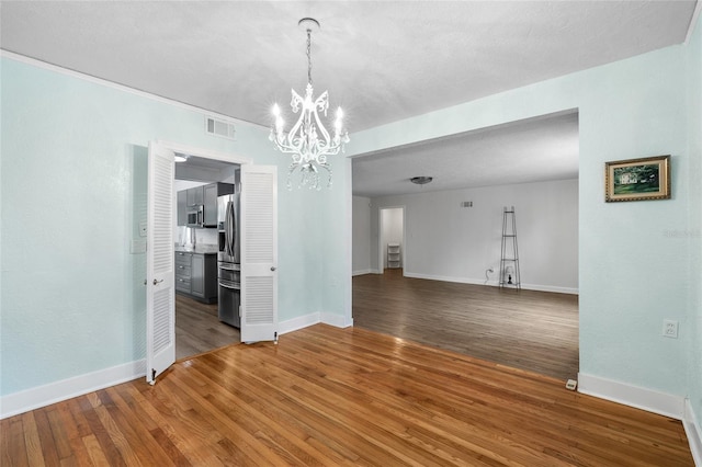 1226 SE 9th Ave, Ocala, FL 34471 - unfurnished dining area with a chandelier, baseboards, and wood finished floors
