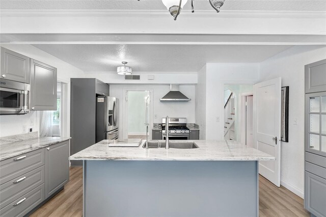 1226 SE 9th Ave, Ocala, FL 34471 - kitchen with gray cabinetry, stainless steel appliances, wall chimney exhaust hood, light wood-style flooring, and a textured ceiling