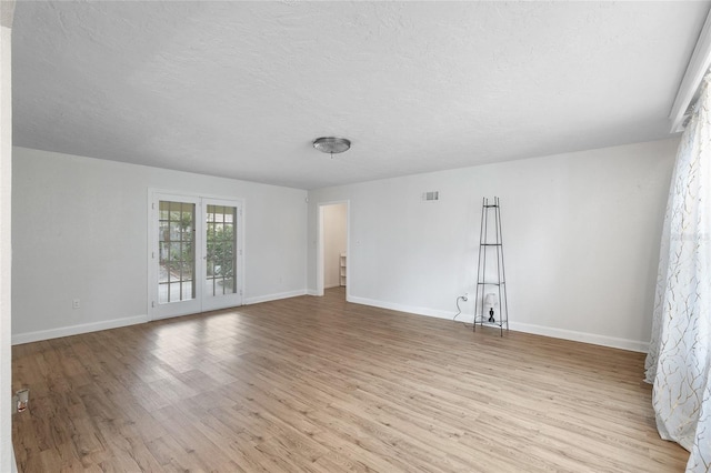 1226 SE 9th Ave, Ocala, FL 34471 - empty room featuring light wood finished floors, a textured ceiling, and baseboards