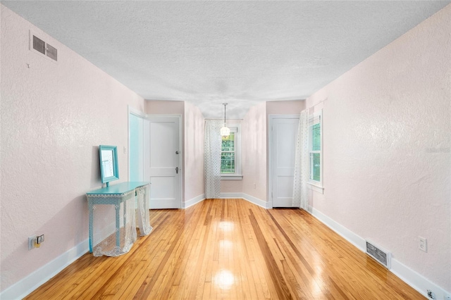 1226 SE 9th Ave, Ocala, FL 34471 - empty room with a textured wall, hardwood / wood-style flooring, baseboards, and a textured ceiling