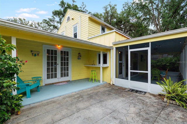 1226 SE 9th Ave, Ocala, FL 34471 - back of property featuring a sunroom, french doors, and a patio area