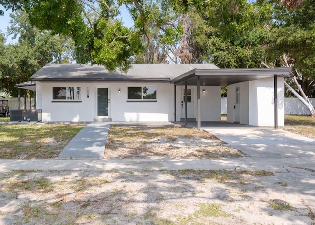 1119 Eau Claire Cir, Tampa, FL 33619 - view of front of home featuring stucco siding, a carport, concrete driveway, and cooling unit