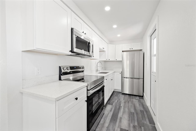 1119 Eau Claire Cir, Tampa, FL 33619 - kitchen with stainless steel appliances, a sink, white cabinets, recessed lighting, and dark wood-style flooring