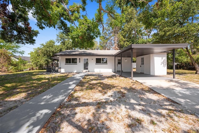 1119 Eau Claire Cir, Tampa, FL 33619 - view of front of house featuring stucco siding, driveway, an attached carport, and cooling unit