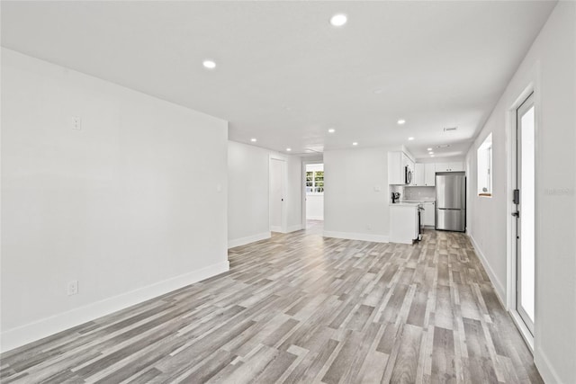 1119 Eau Claire Cir, Tampa, FL 33619 - unfurnished living room with recessed lighting, light wood finished floors, and baseboards