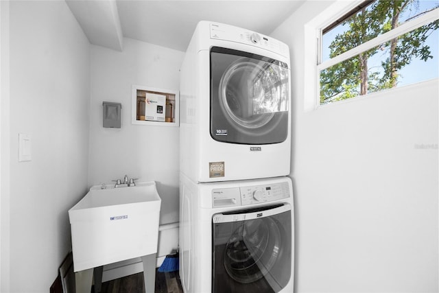 1119 Eau Claire Cir, Tampa, FL 33619 - laundry room featuring stacked washer / dryer and wood finished floors