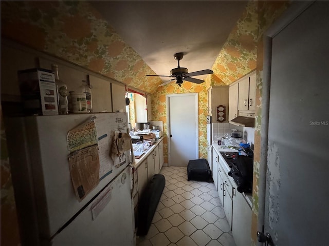 3730 NE 17th Ave, Pompano Beach, FL 33064 - kitchen featuring a ceiling fan, light tile patterned floors, under cabinet range hood, vaulted ceiling, and freestanding refrigerator