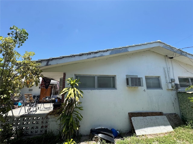 3730 NE 17th Ave, Pompano Beach, FL 33064 - view of side of property featuring stucco siding, a patio, and a wall mounted AC