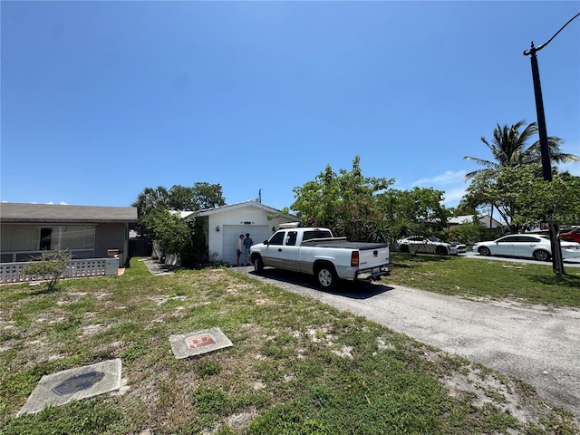 3730 NE 17th Ave, Pompano Beach, FL 33064 - view of grassy yard with asphalt driveway and an attached garage