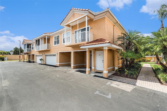 21007 Sunpoint Way Unit 203, Lutz, FL 33558 - townhome / multi-family property with stucco siding, a balcony, an attached garage, and a tiled roof