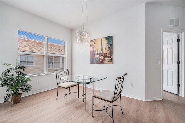 21007 Sunpoint Way Unit 203, Lutz, FL 33558 - dining area with light wood-type flooring, baseboards, and a chandelier