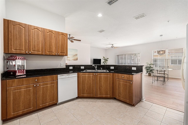 21007 Sunpoint Way Unit 203, Lutz, FL 33558 - kitchen with dishwasher, ceiling fan, a sink, a peninsula, and brown cabinets