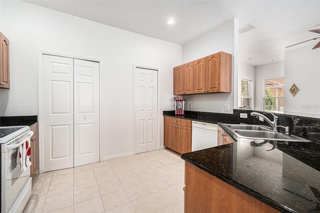 21007 Sunpoint Way Unit 203, Lutz, FL 33558 - kitchen with white appliances, a sink, light tile patterned floors, dark stone countertops, and brown cabinetry